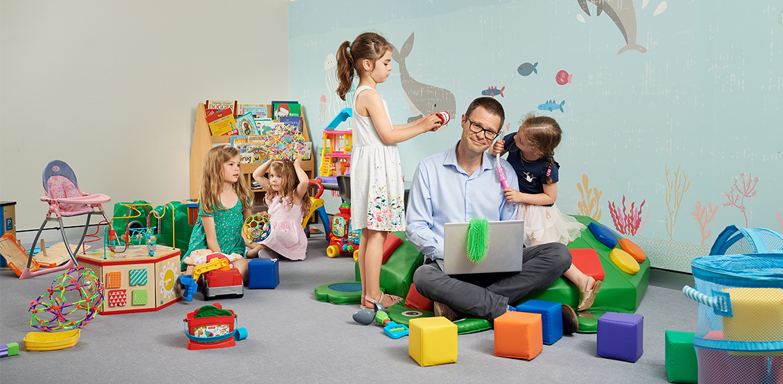 Professor Andrew Whitehouse surrounded by playful children in the busy clinic in Subiaco Western Australia.