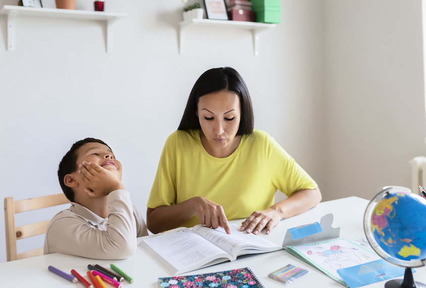 Woman going over homework with distracted child.
