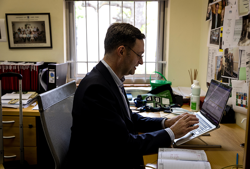 Petrus deVries in his office, working on a laptop computer.