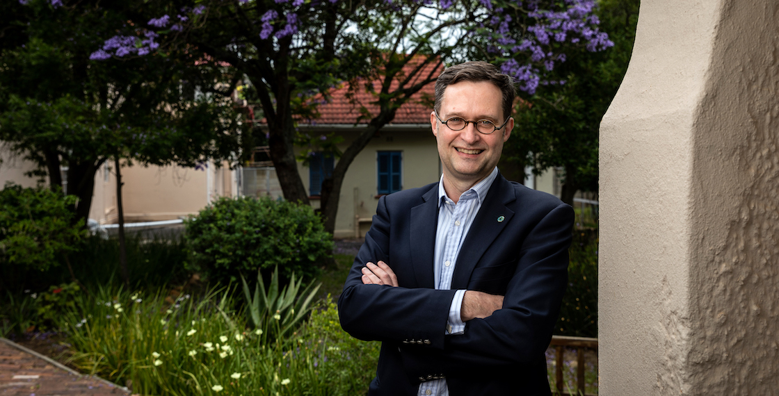 portrait of Petrus Petrus deVries with flowering tree in background.