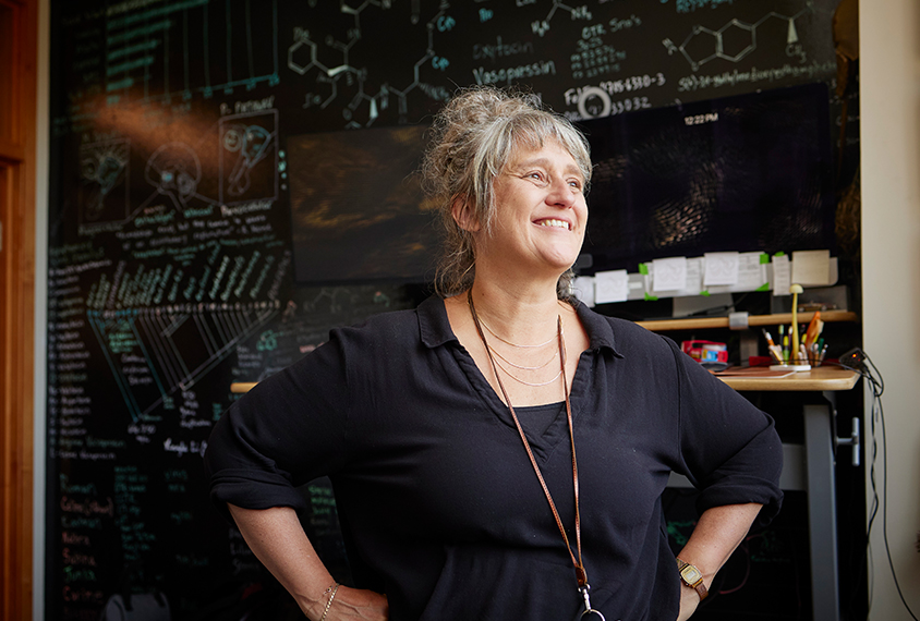 Scientist Gül Dölen smiles while looking towards the window in her lab's office.