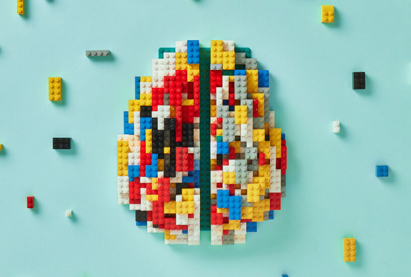 An abstract representation of a brain formed from multi-colored Legos. 