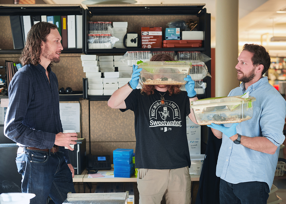 Lab manager Sawyer Grizzard and graduate student Sean Gay hold mouse cages while Diering stands to the left holding a coffee.