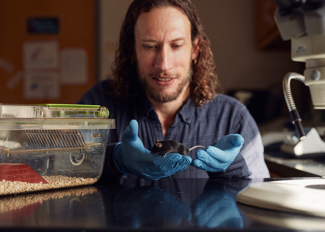 Graham Diering with a mouse in his lab.