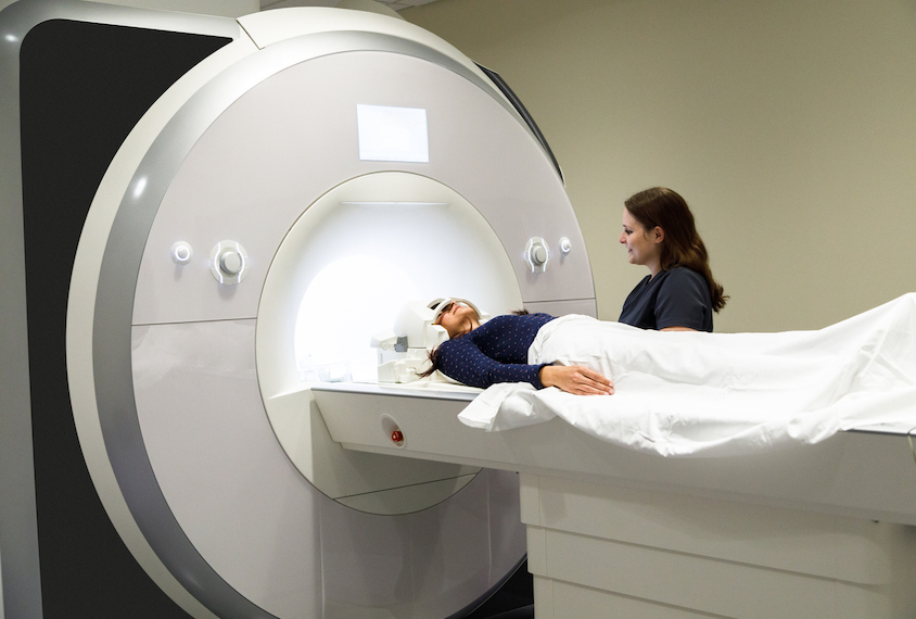 A photograph of a person preparing for an fMRI scan