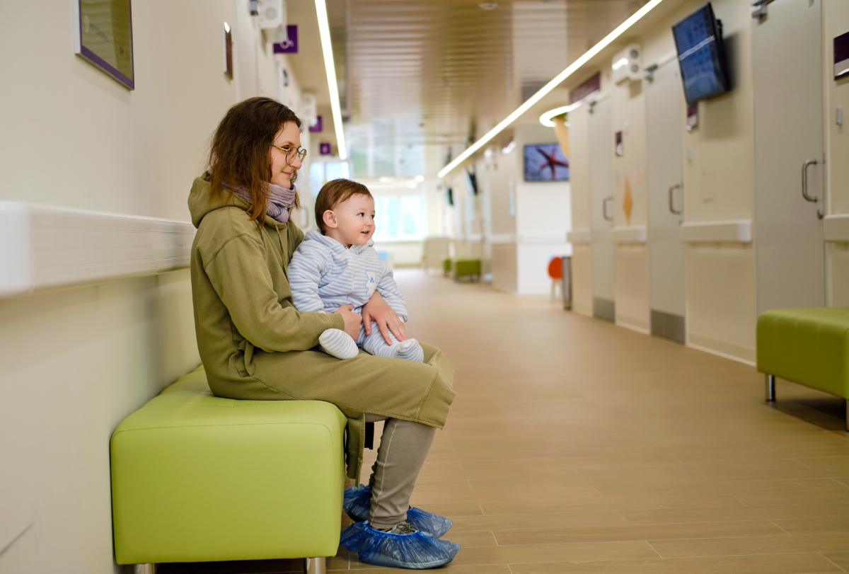 Photograph of a mother with her child in a hallway waiting for an appointment.