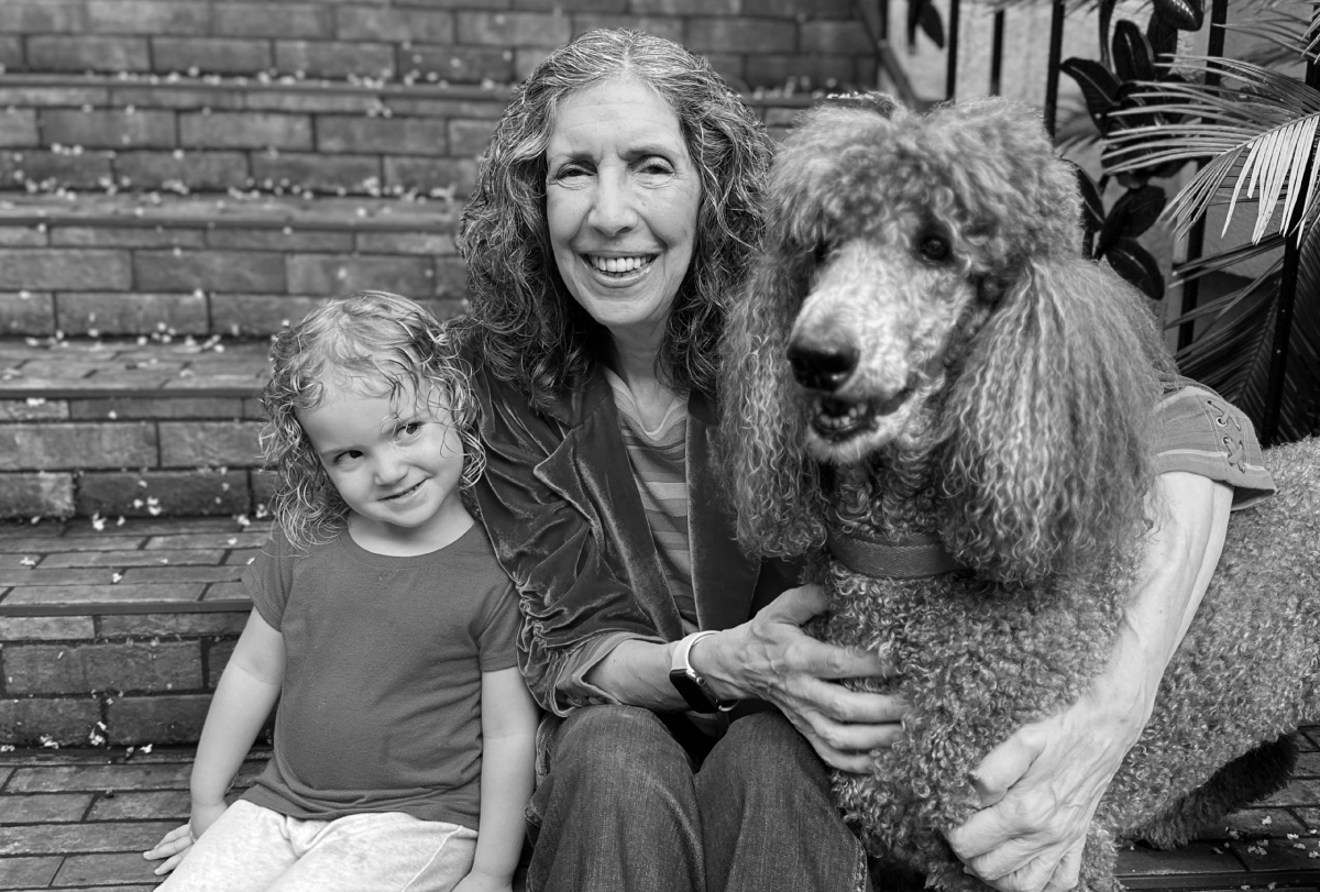 Amy Wetherby sits outside with her granddaughter and poodle.
