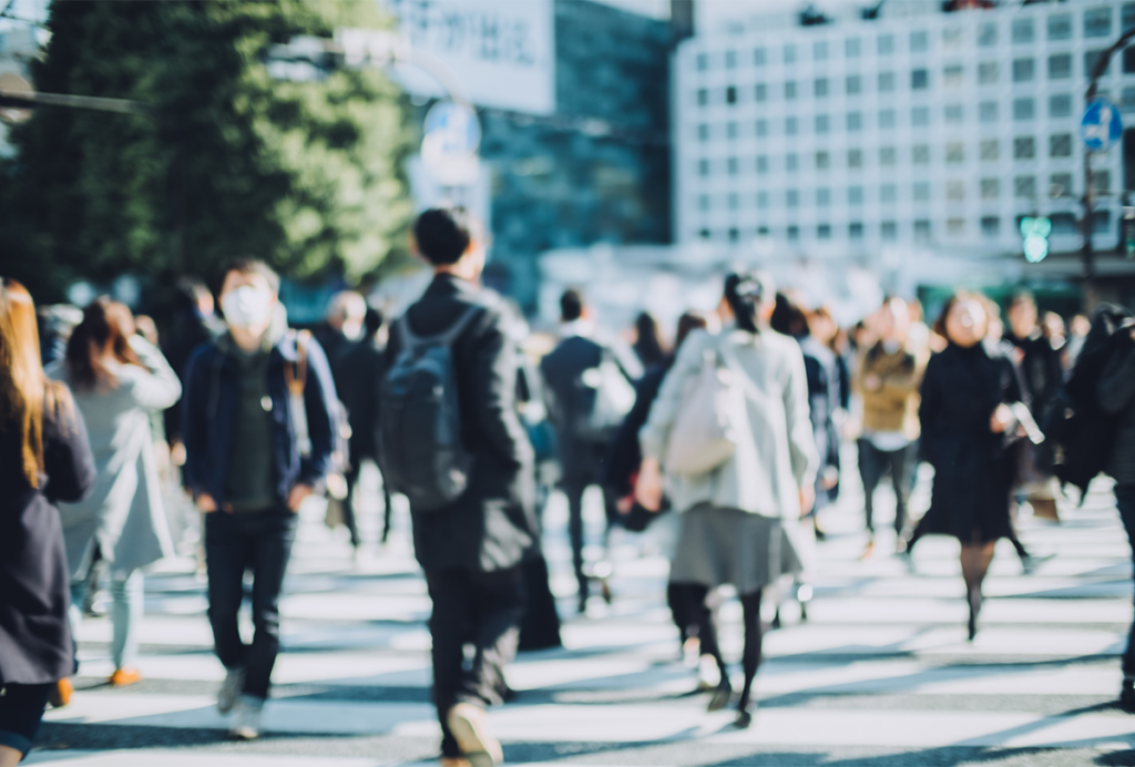 Blurry photograph of a crowd of people on a street.