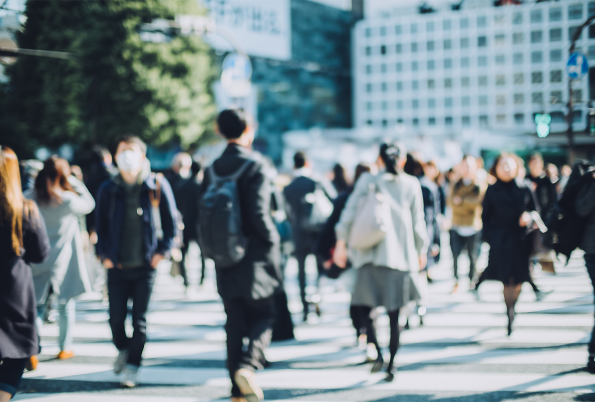 Blurry photograph of a crowd of people on a street.