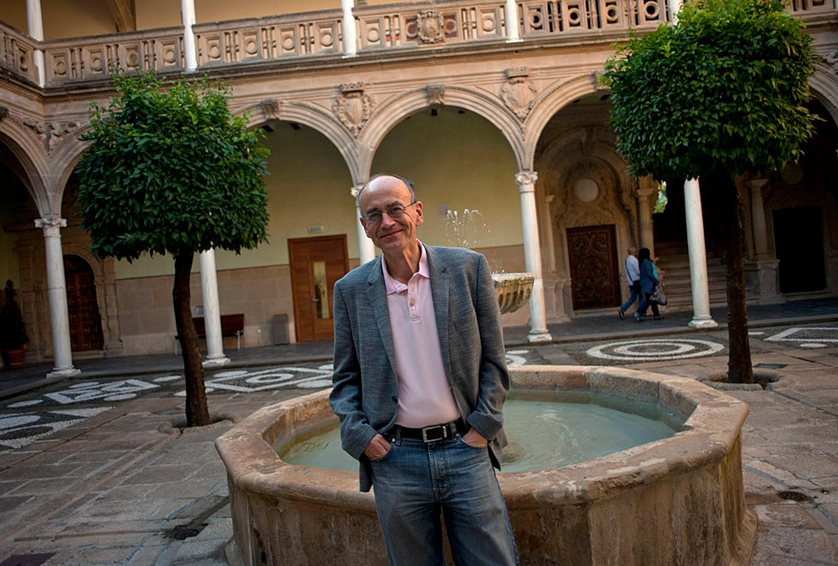 A photograph of Thomas Sudhof standing in a courtyard