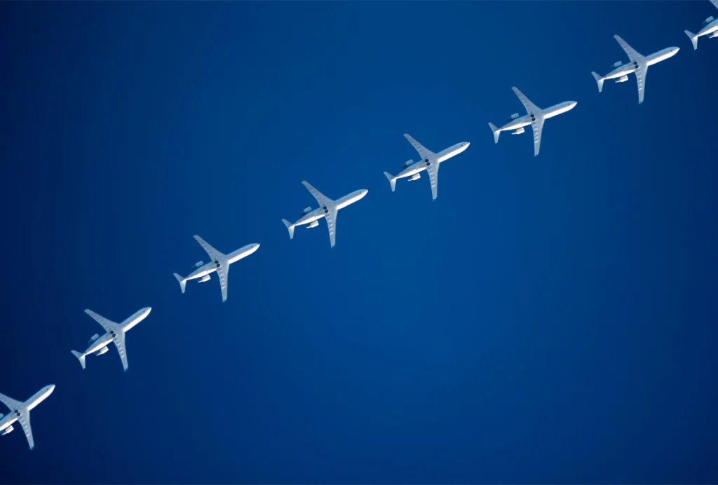 A line of airplanes flies across the sky.