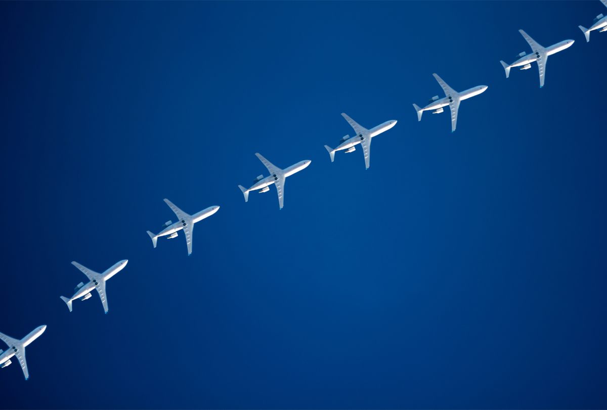 A line of airplanes flies across the sky.