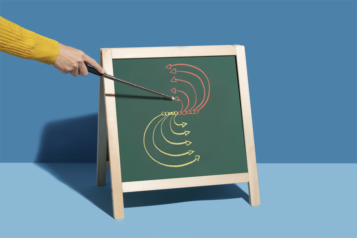 A hand points to an illustration on a chalkboard.