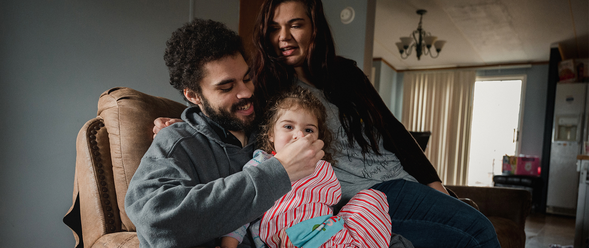 Coraline’s father feeds her in a playful moment at home.