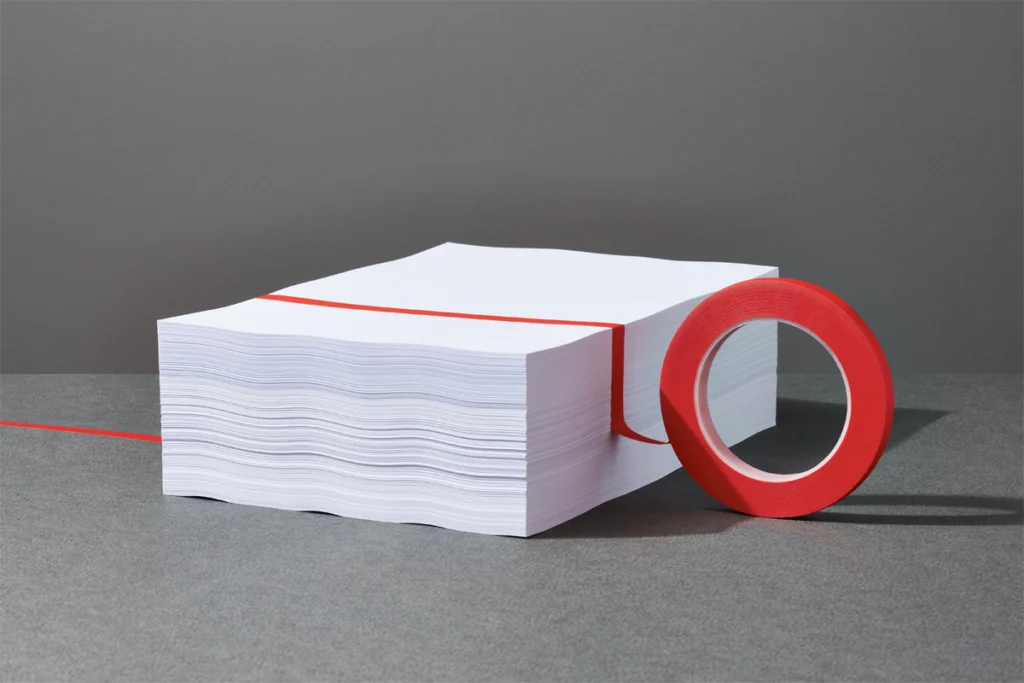A stack of papers with red tape.