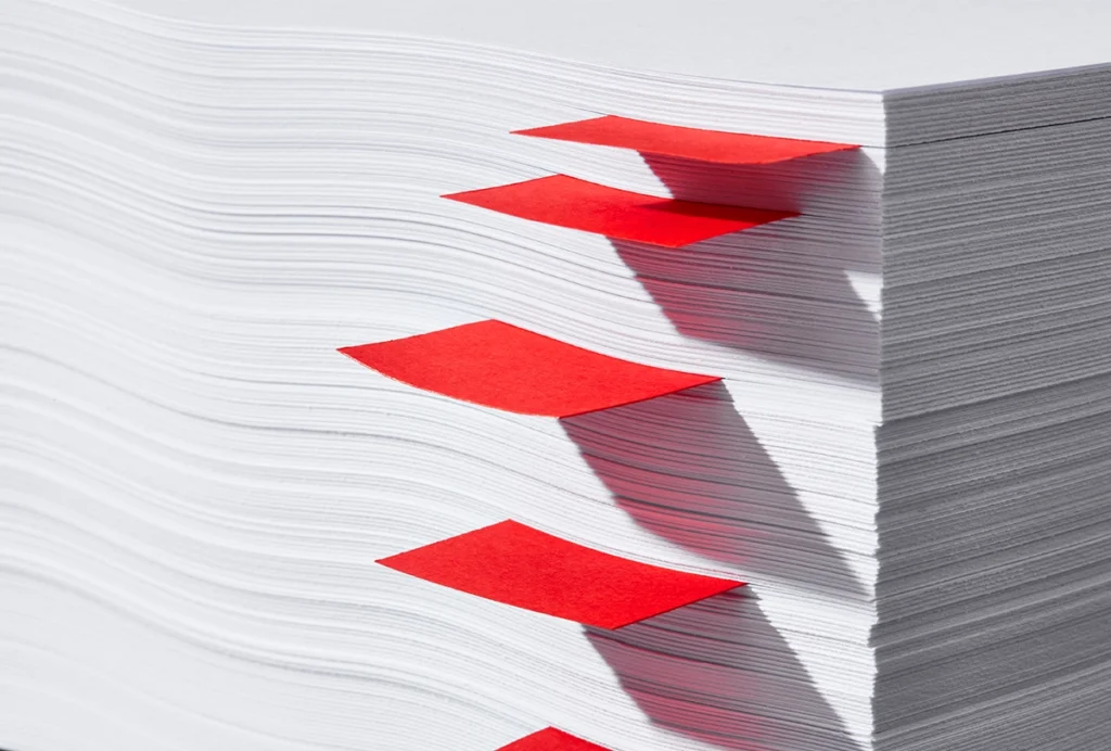 A stack of papers with red bookmarks