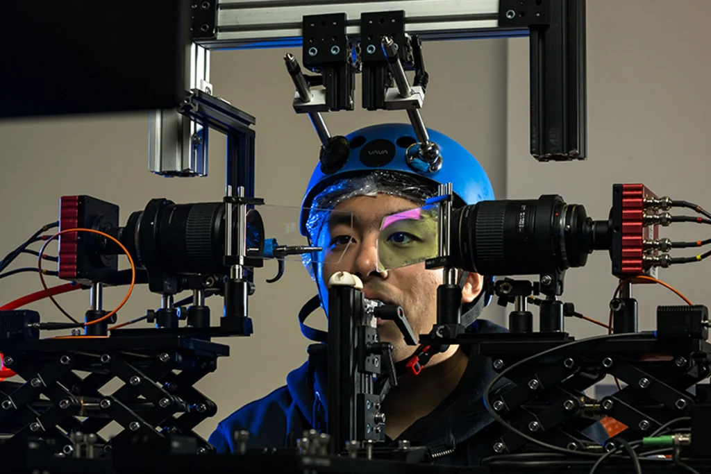 A person sits in an experimental rig that examines eye movements.