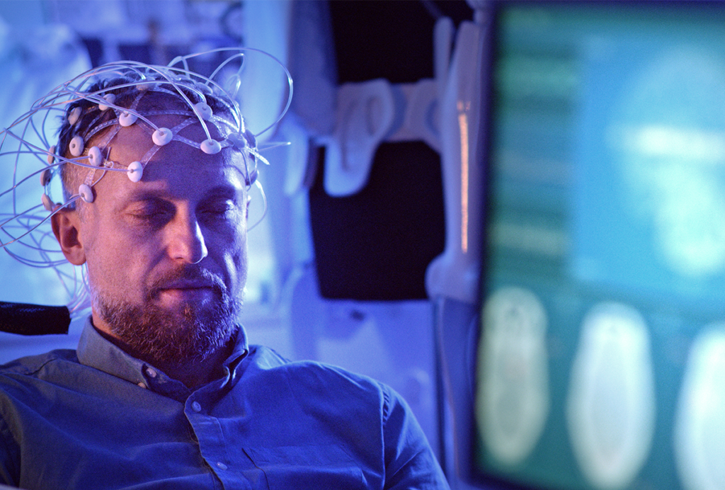 Man with EEG sensors on his head.