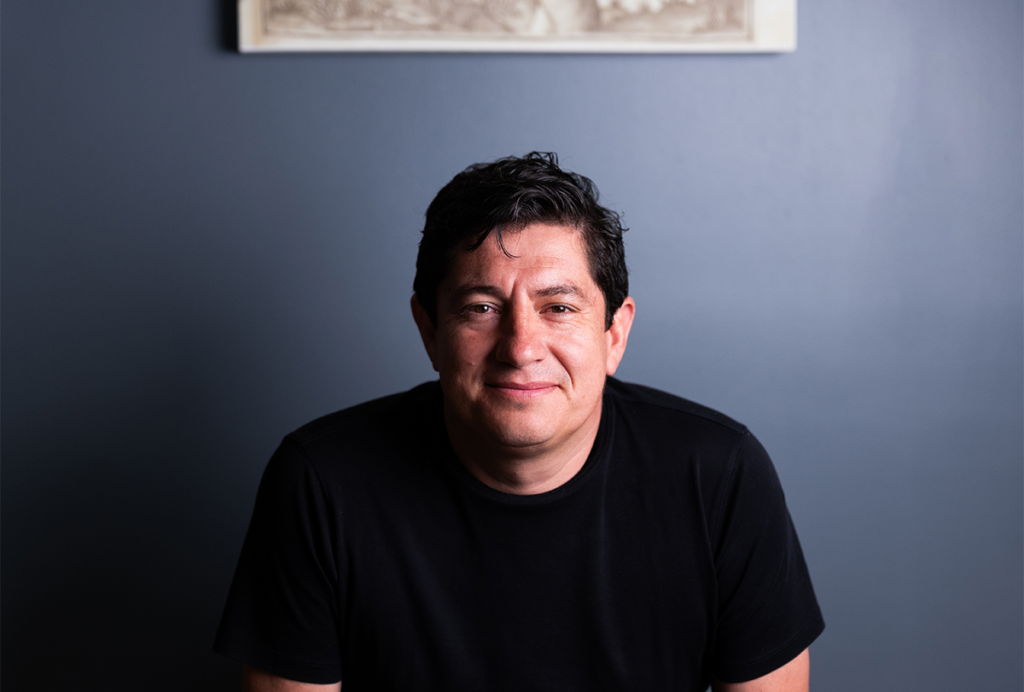 Diego Bohorquez portrait on blue background.