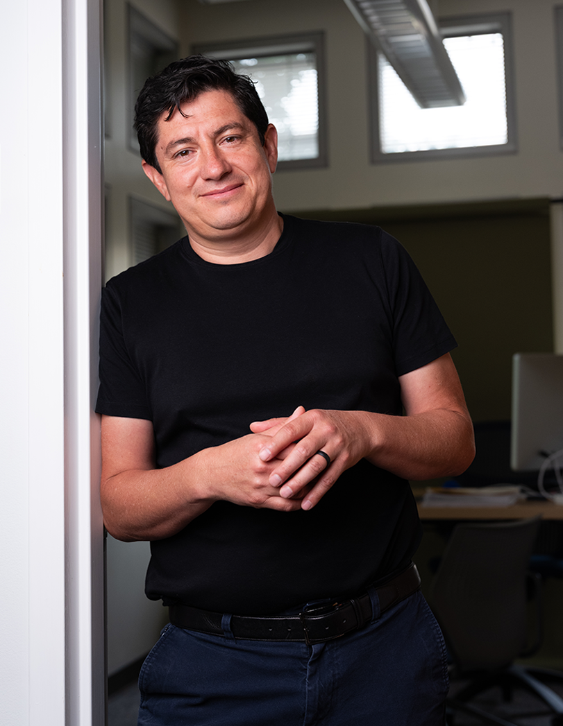 Diego Bohorquez smiles, leaning on a door frame.