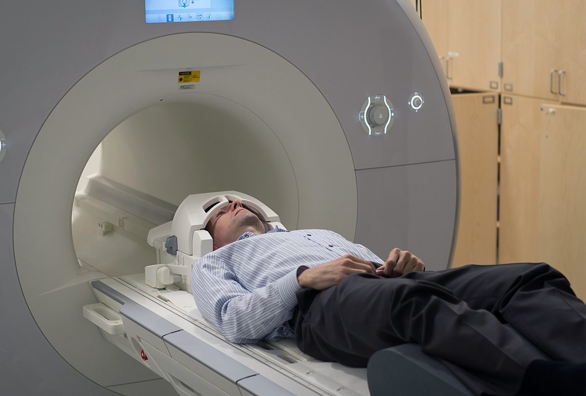 Researcher Russell Poldrack' laying down, about to be scanned in an MRI machine.