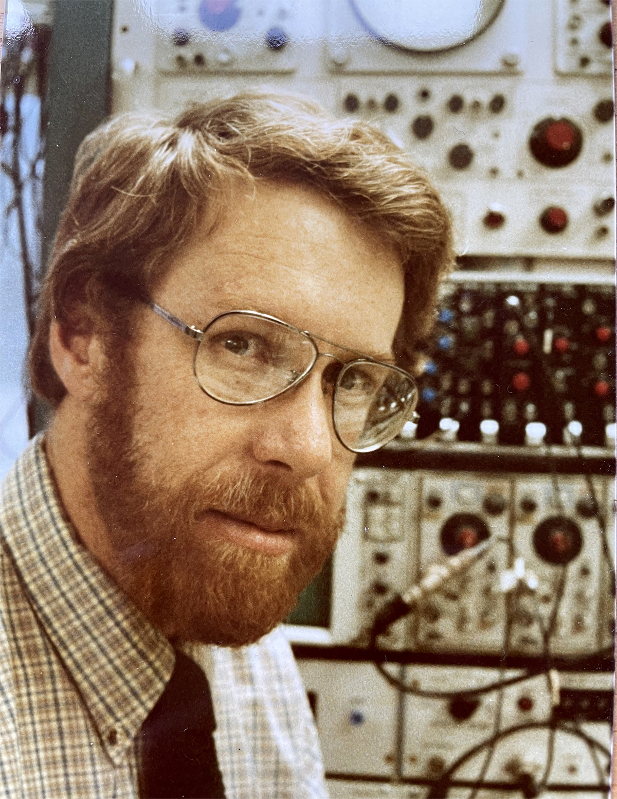 Howard Fields in front of lab equipment.