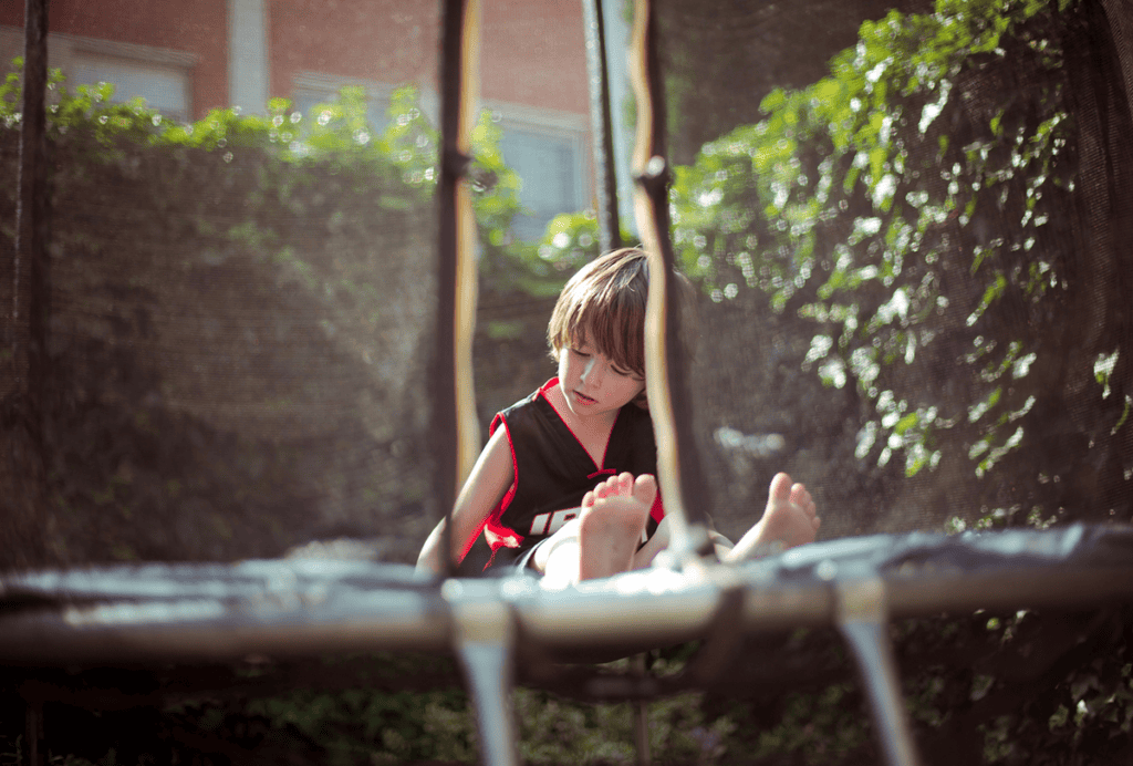 Child sitting on a trampoline.