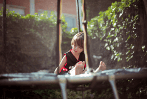 Child sitting on a trampoline.