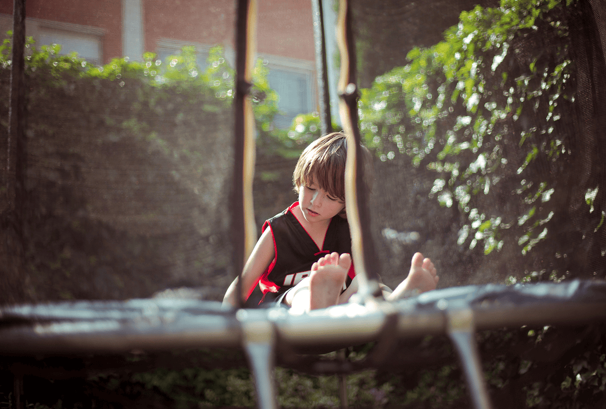 Child sitting on a trampoline.