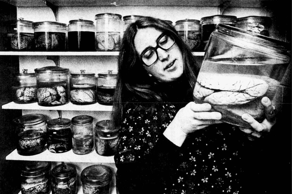 Barbara Finlay looking at a glass jar with a brain.