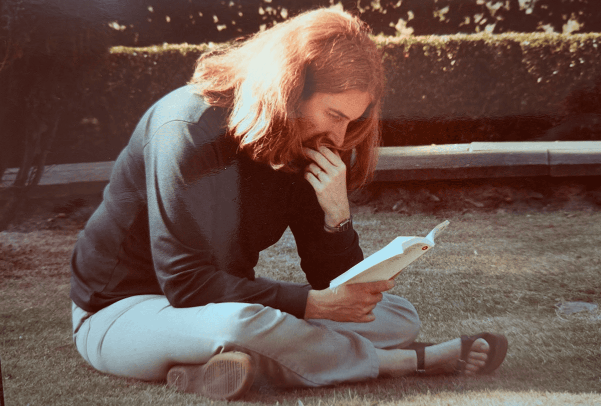 Barbara Finlay sitting on grass reading a book.